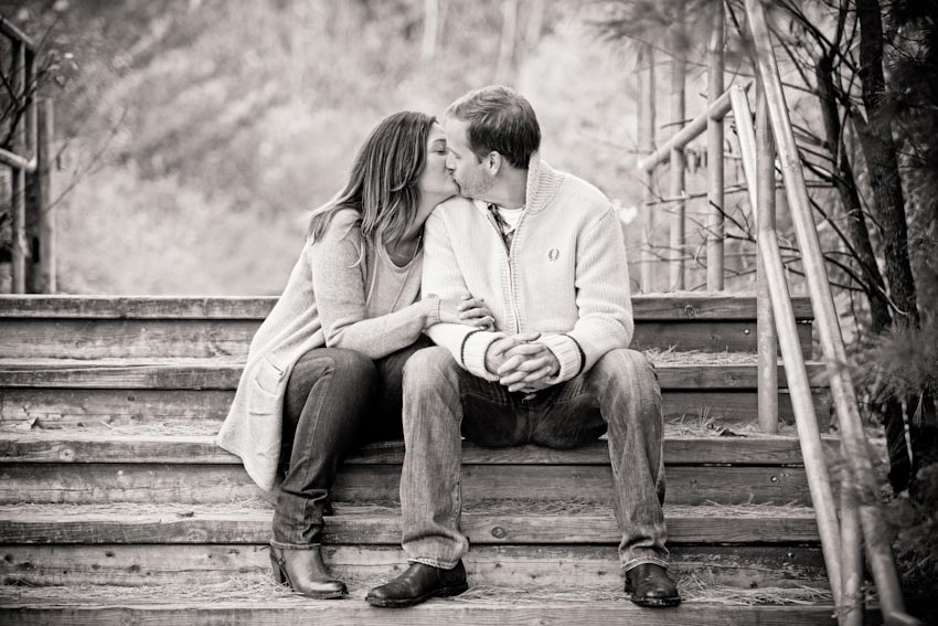 black and white photo of engaged couple kissing