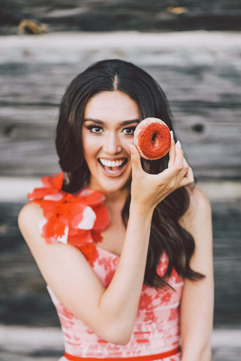 bride holding donut next to her eye