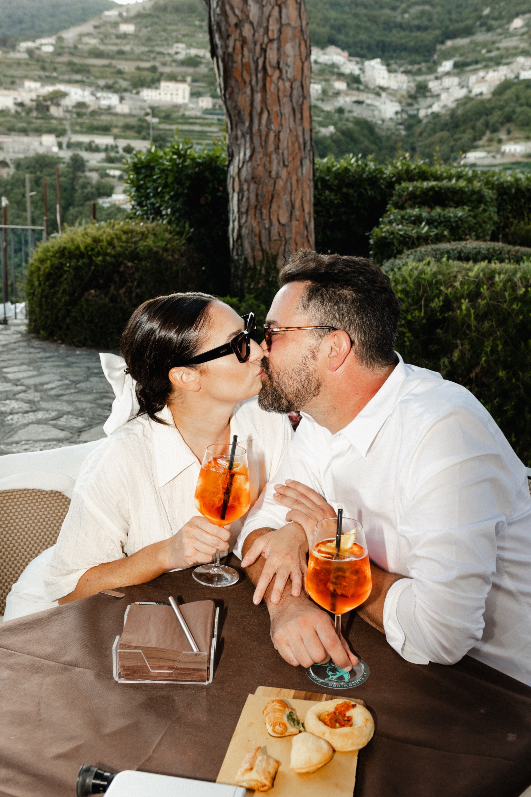 Couple kissing and having Aperol Spritz at a Italian Café