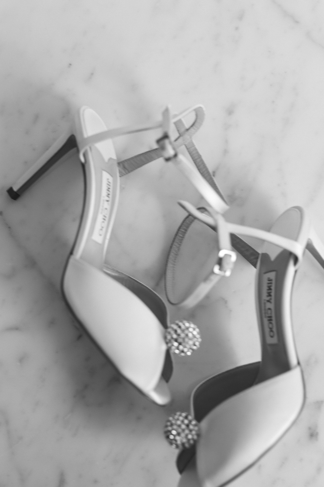 a pair of white high heeled shoes in black and white