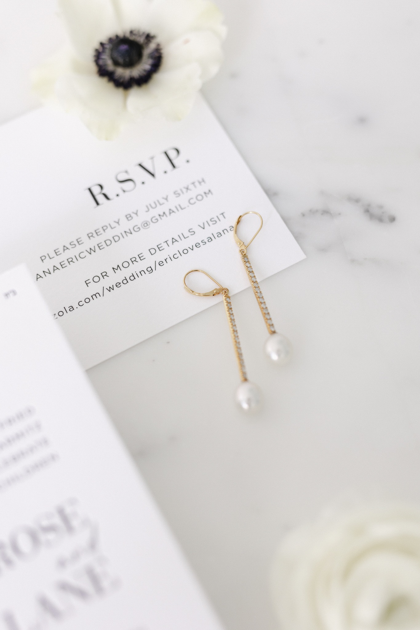A pair of earrings on a white R.S.V.P card.