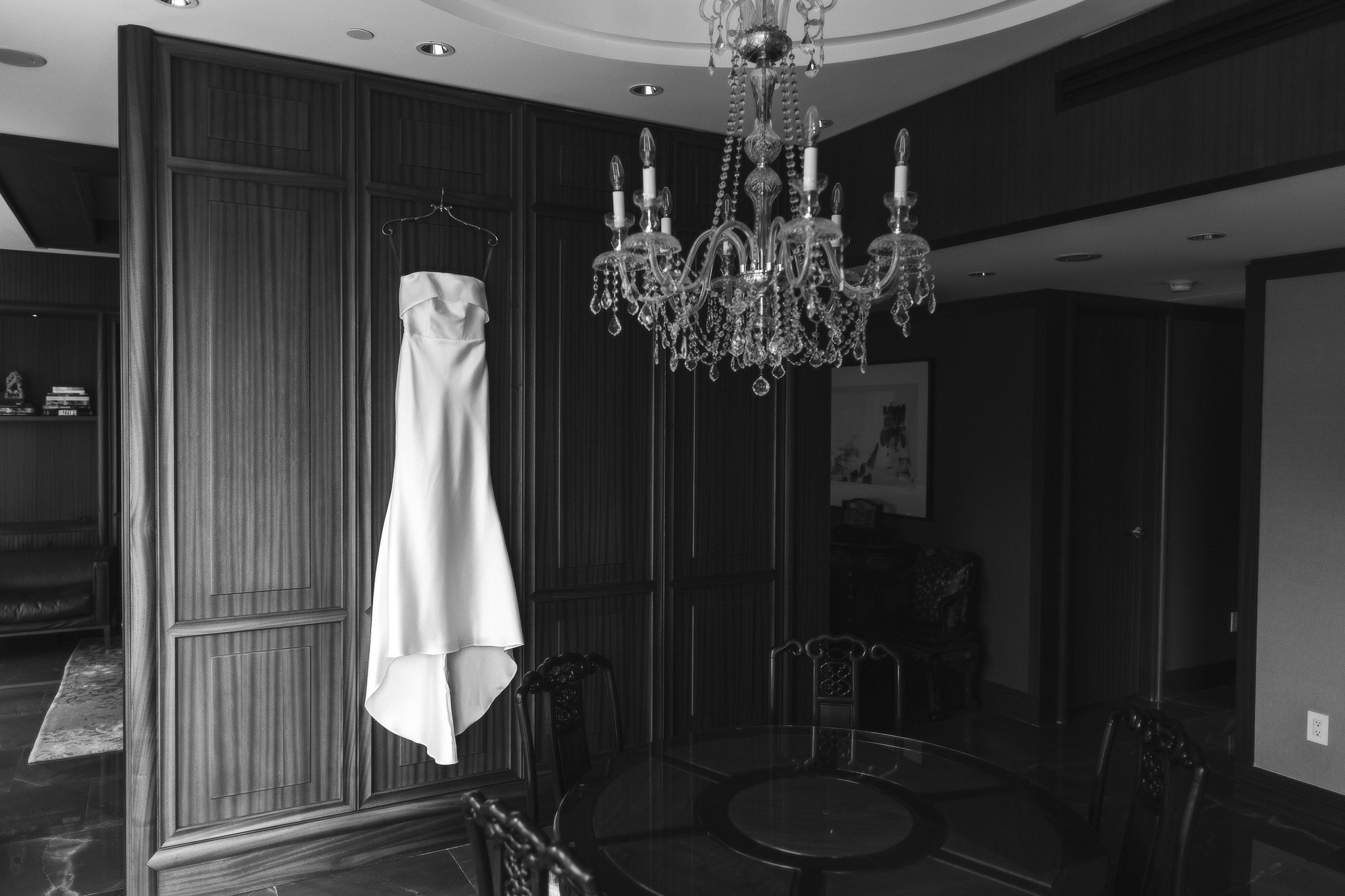 Wedding dress hanging on a wall, black and white.