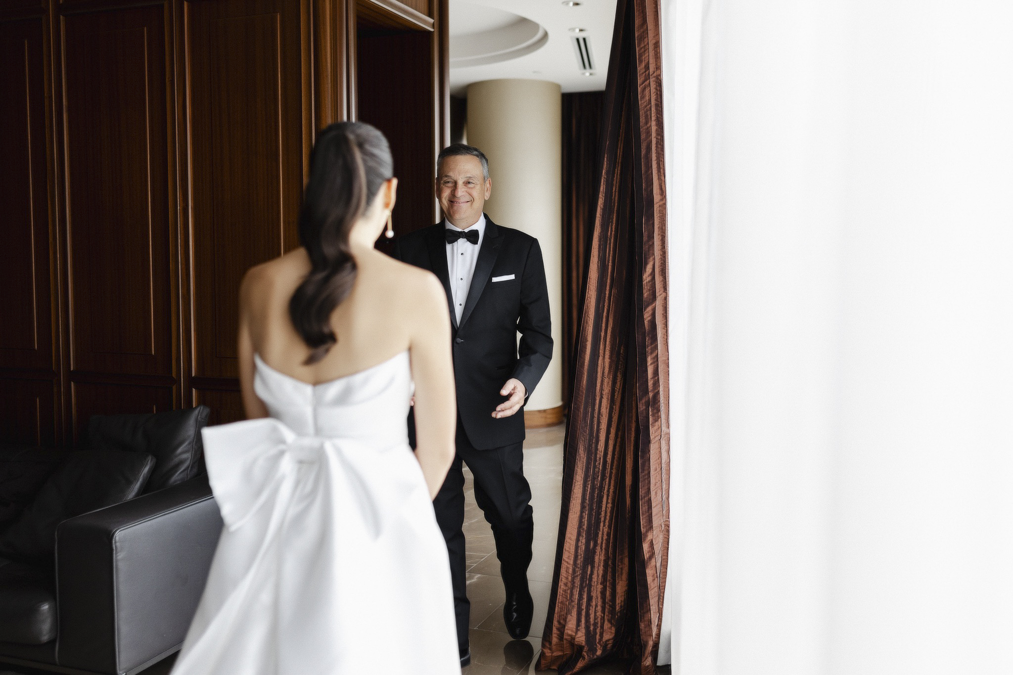 Dad looking at daughter (bride) for first time in wedding dress.