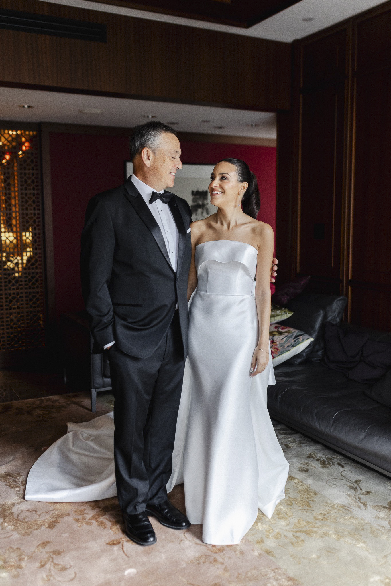 Portrait of bride with her dad in hotel suite.