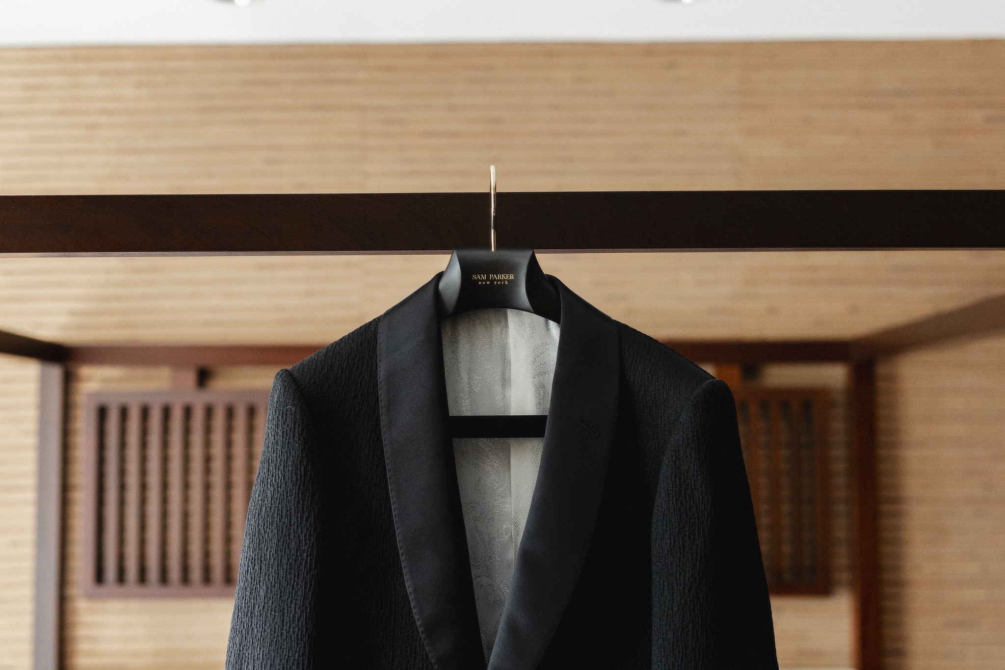 Groom suit hanging on a wall.